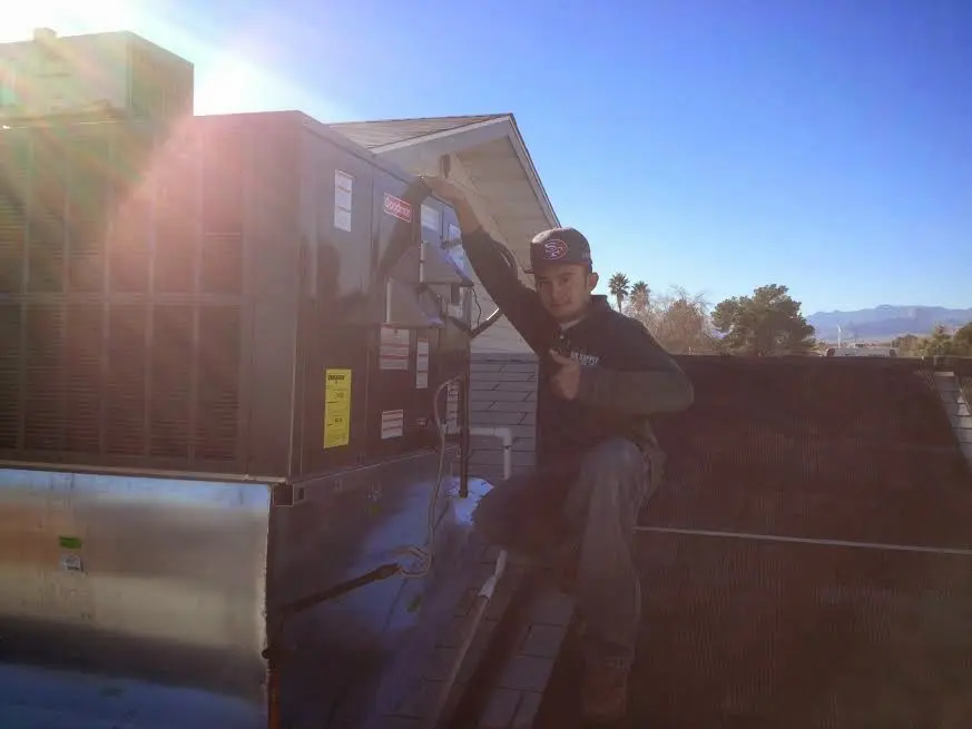 HVAC technician performing AC Tune-Up on a rooftop unit in Los Fresnos